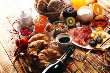 breakfast on table with bread buns, croissants, coffe and juice on new years eve