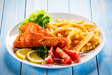 Fried salmon, French fries and vegetables
