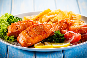 Fried salmon, French fries and vegetables