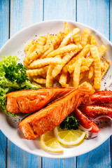 Fried salmon, French fries and vegetables