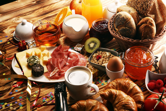 breakfast on table with bread buns, croissants, coffe and juice on new years eve