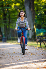 Fototapeta premium Urban biking - woman riding bike in city park
