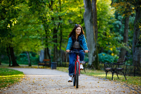 Urban biking - woman riding bike in city park