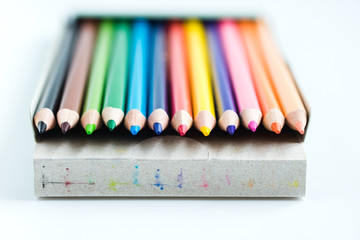 Wooden color pensils in box on white background