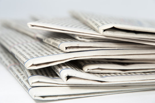 stacked newspapers on white background