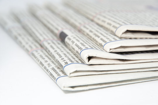 stacked newspapers on white background