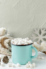 Mug of cocoa with marshmallows and winter decor
