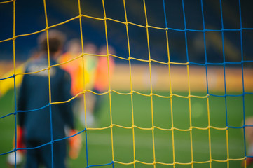 Soccer net with a blurred background. At the stadium, in the spotlight. Football game moment.