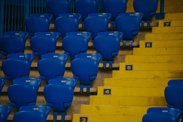 Fototapeta premium Niebieskie puste miejsca na stadionie piłkarskim. Żółte schody z kilkoma sektorami.