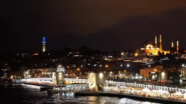 Scenic view at night Istanbul with Galata Bridge and Suleymaniye Mosque with beautiful backight. Ferry sails on Golden Horn gulf under Galata Bridge. 4k video footage