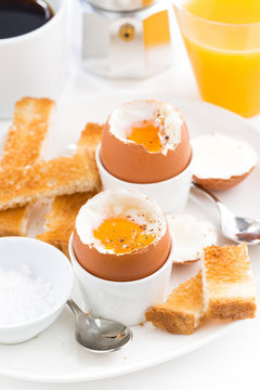 soft boiled eggs, crispy toast and coffee for breakfast, vertical