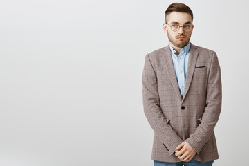 Intense worried european male employee feeling awkward and confused making mistake being scolded by boss feeling discomfort being in uncomfortable situation holding hands near pants and gazing aside