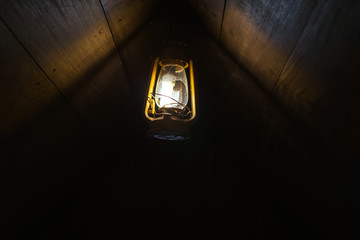 An old lamp hanging on a dark attic