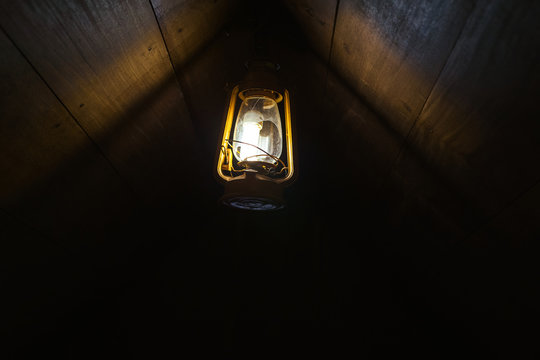 An Old Lamp Hanging On A Dark Attic