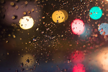 Abstract background. Drops on the glass in the night with bokeh color circles