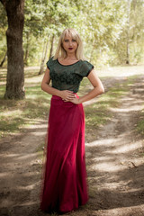 Portrait of  beautiful vintage style model with blond hair in a marsala chiffon skirt and green...