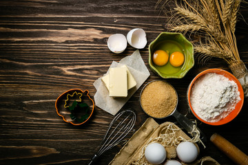 Baking concept - baking ingredients butter, flour, sugar, eggs on rustic wood background, top view
