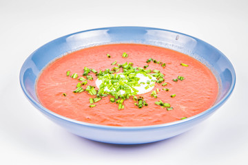 Beetroot cream soup decorated with yogurt mixed and chives