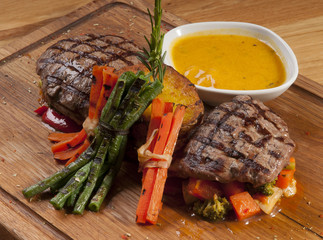 grilled beef steak on wooden board with sauce