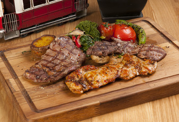 grilled meat and chicken on wooden board