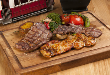 grilled meat and chicken on wooden board