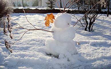 Snow figure in rays of sun. Favorite winter fun sculpting a snowman. Christmas, New Year,...