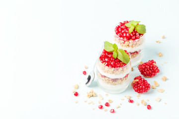 Pomegranate parfait - sweet organic layered dessert with granola flakes, yogurt and ripe fruit seeds.