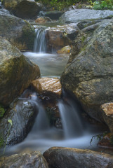 Naklejka na ściany i meble A small mountain waterfall on the creek