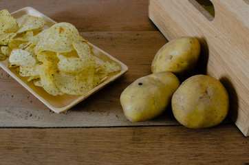 fried cripy potato on wood plate and three potato on wood background,