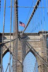 Obraz premium New York, USA - November 22, 2010: The historic Brooklyn Bridge in New York City with US flag