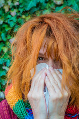 a woman has a cold and uses a handkerchief
