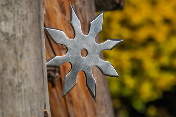 Shuriken (throwing star), traditional japanese ninja cold weapon stuck in wooden background