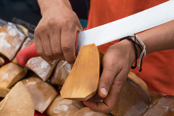  El trabajador corta un pedazo de mezcal, dulce de agave.