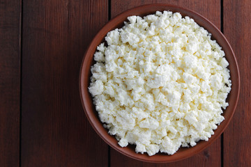Cottage cheese. Cottage cheese on wooden boards. Soft cheese in earthenware dish. Milk product with wooden spoon. Copy space