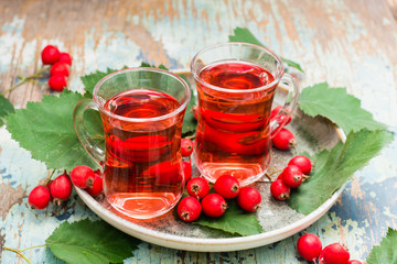Hot tea from hawthorn berries in transparent glasses on a wooden table