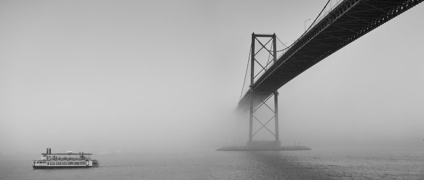 Fototapeta Ferry boat crossing under a suspension bridge in Halifax, Nova Scotia in thick fog. 