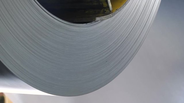 Steel sheets rolled up into rolls. Export Steel. Packing of steel for transportation. Roll of galvanized steel sheet. Close up view.