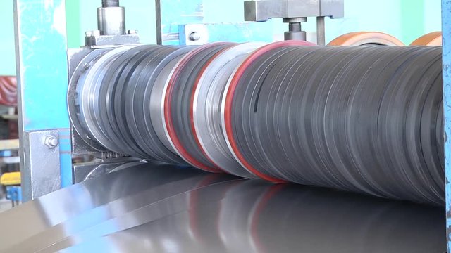 Cold rolled steel coil on decoiler of machine in metalwork manufacturing. High precision sheet metal cutting machinery. Coils cutter machine. Industrial and business concept.