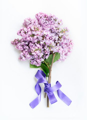 Fresh lilac flowers bouquet over white background, flat lay top view scene