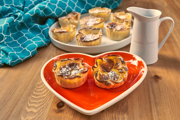 Red heart-shaped dish with pastries lover sighs for Valentine's Day.