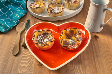 Red heart-shaped dish with pastries lover sighs for Valentine's Day.