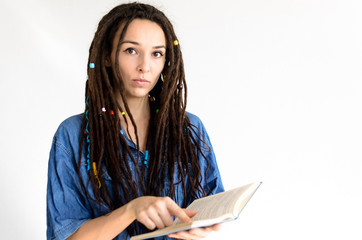 serious girl with dreadlocks shows a finger in a book on a white background