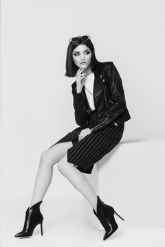 Fashion portrait of a young woman in leather jacket. Black and white image