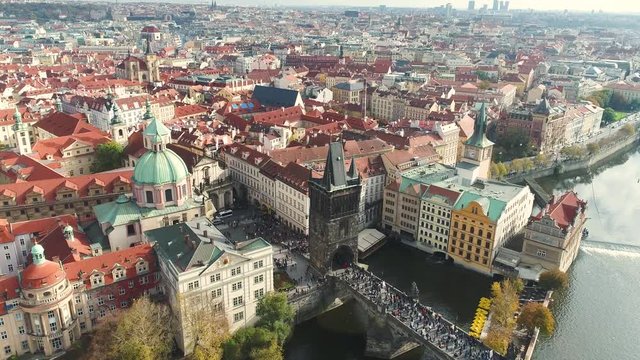 Panoramic view from above to the city of Prague and Charles Bridge, tourists on the Charles Bridge, Vltava River, flight over the Charles Bridge