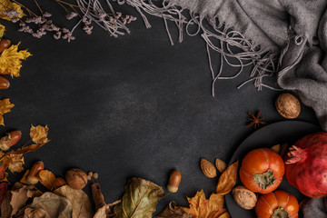 Autumn composition of dry leaves, fruits and flowers on a dark background. Top view. Copy space