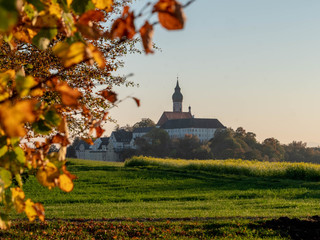 Blick auf das Kloster Andechs im Herbst bei letzten Sonnenlicht
