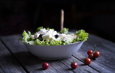 Obraz na płótnie Canvas Plate with Fresh Greek salad on a wooden background
