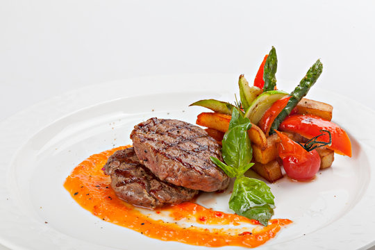 Barbecue Beef Steaks medium rare with grilled potaoes and vegetables.