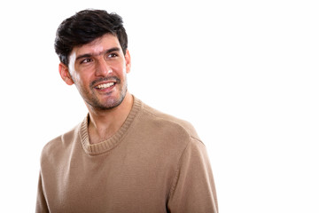 Fototapeta premium Studio shot of young happy Persian man smiling while thinking an