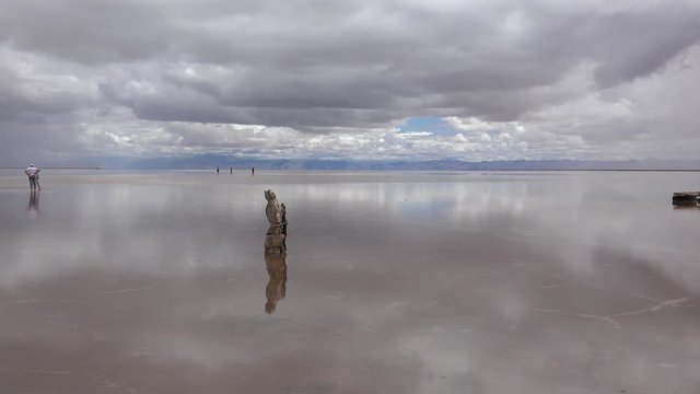 Tourist is walking barefoot in the shallow water of  Salinas Grandes. Jujuy & Salta provinces, Argentina